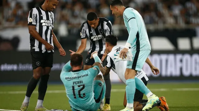 Compañeros de Perri lo consuelan tras la victoria de Botafogo.
